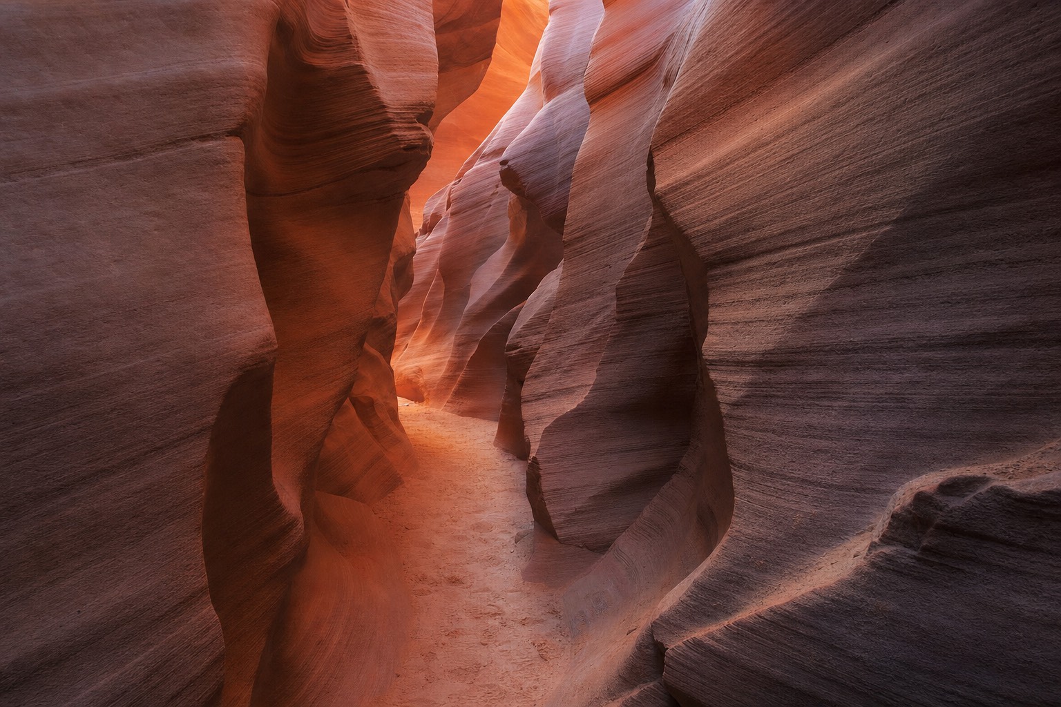 Slot canyon walls in soft even winter light with warm orange and purple tones