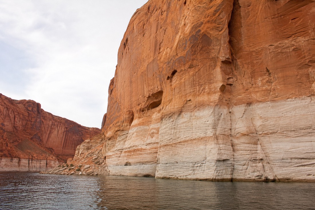 White mineral bathtub ring on tall sandstone walls above the lowered waterline of Lake Powell