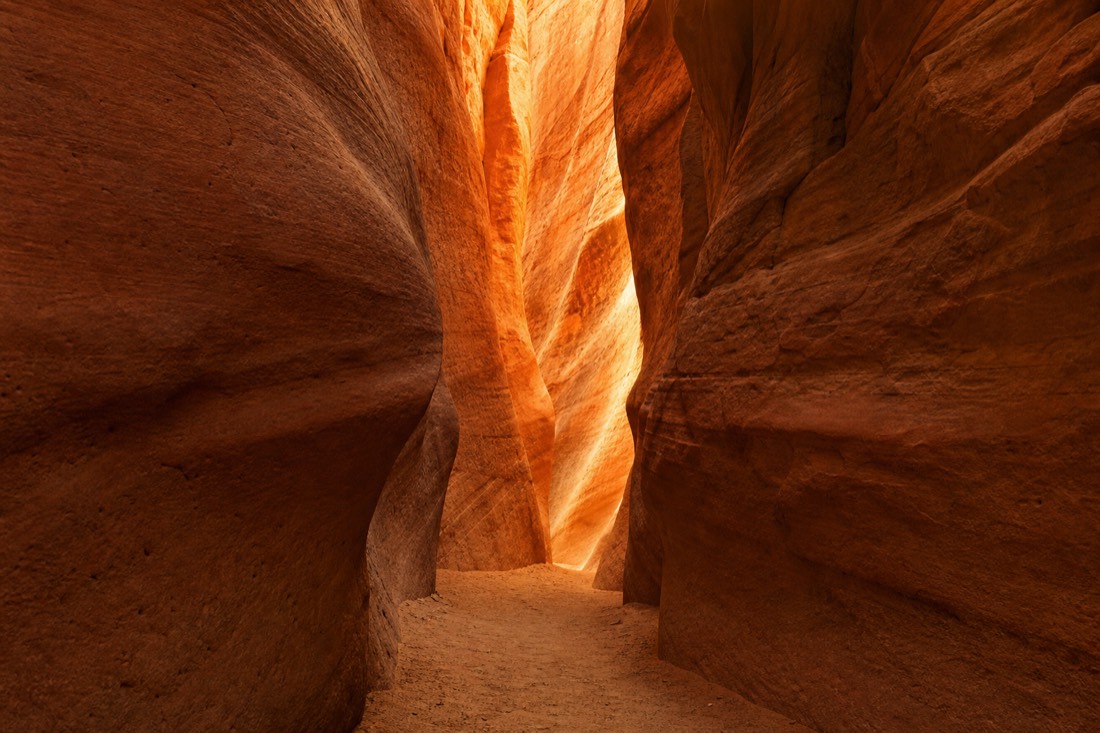 Narrow sandstone slot canyon walls glowing orange with no crowd inside