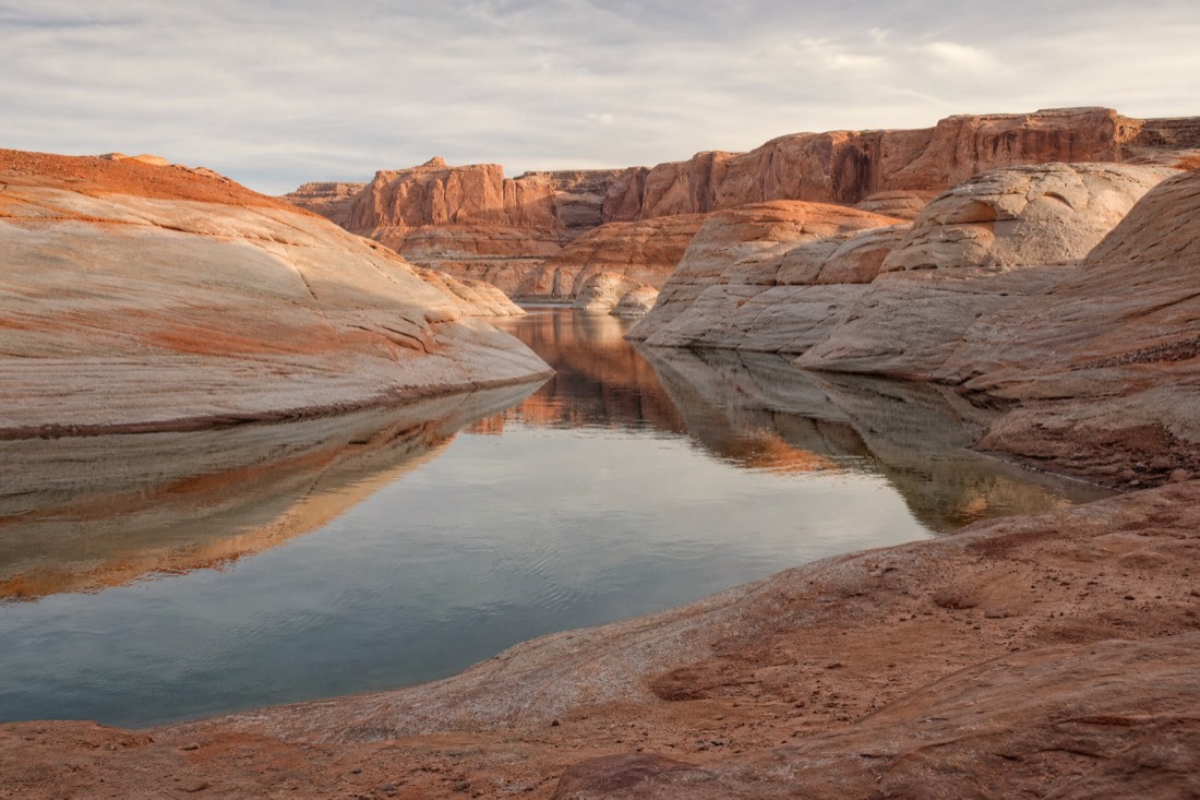 Remote Lake Powell inlet with still water and bare rock resembling an uninhabited planet