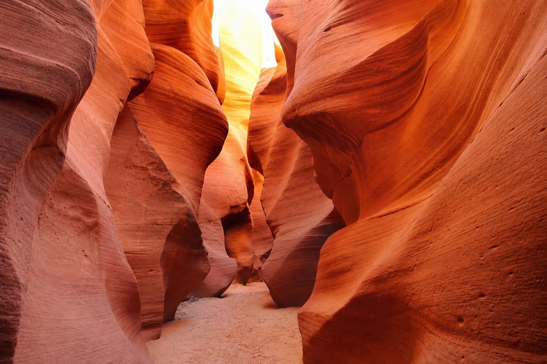 Sculpted orange sandstone waves inside a narrow slot canyon passage
