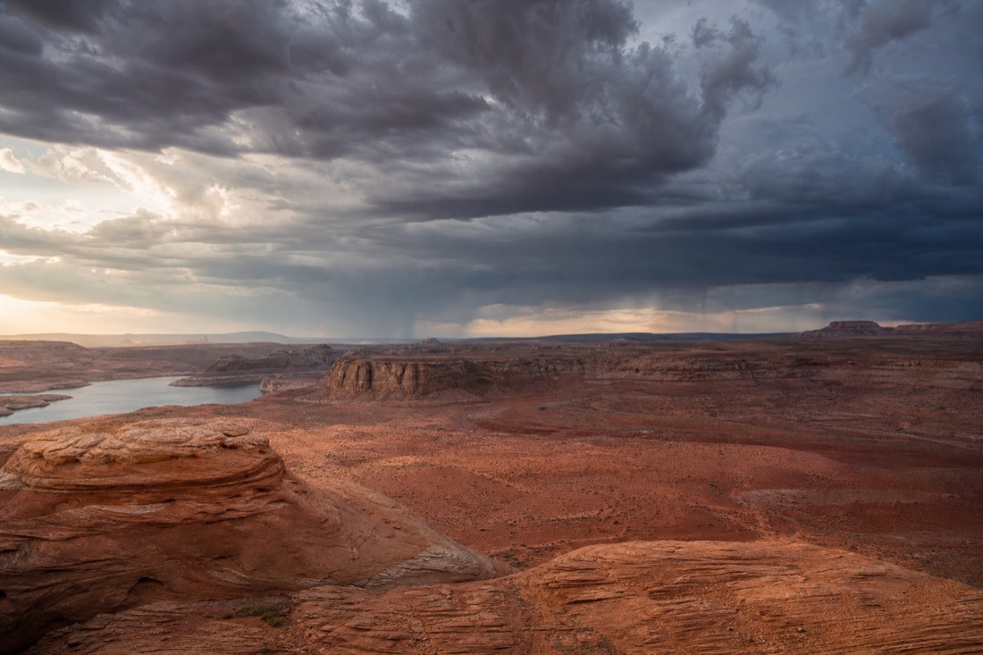 Summer monsoon thunderstorm building over red rock desert near Page Arizona