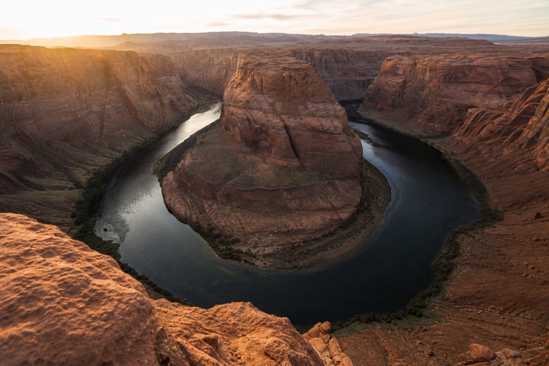 Sweeping U-turn of the Colorado River around a sandstone butte seen from the Horseshoe Bend rim