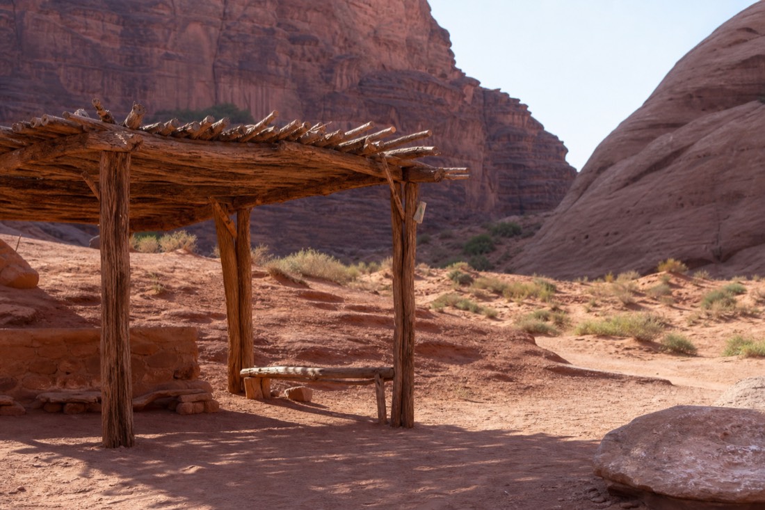 Tour check-in area in the desert with visitors waiting under a shade structure