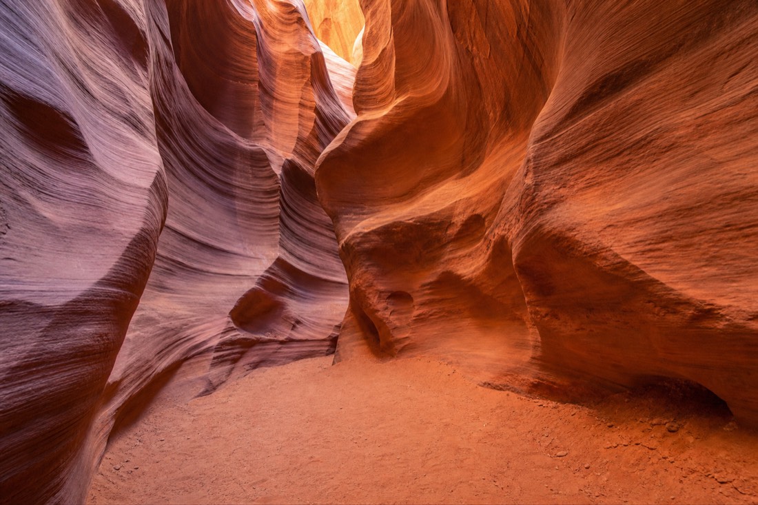 Sculpted sandstone walls curving above an empty passage in Antelope Canyon X